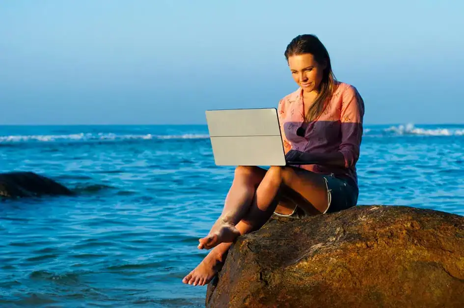 A Woman with a Laptop at the Beach