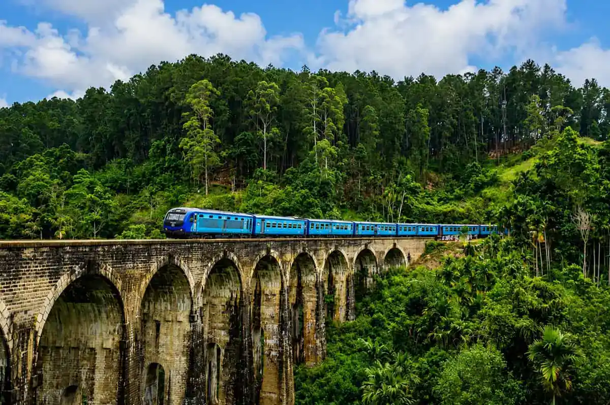 Blue train crossing Nine Arch Bridge near Ella